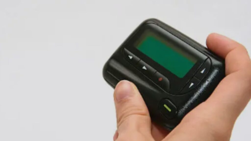 a hand holding a Pager Device